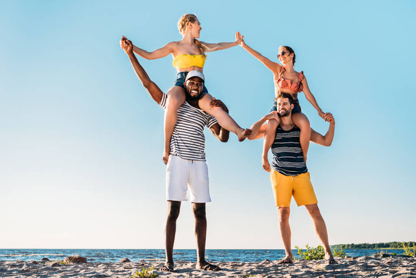 boldog fiatal többnemzetiségű meg szórakozik együtt homokos strandon  - Fotó, kép