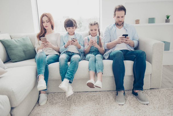 Portrait of family with two kids having holding smart phone electronic device in hands texting sms using wi-fi 5G internet checking email searching contact. Apps concept - Фото, зображення