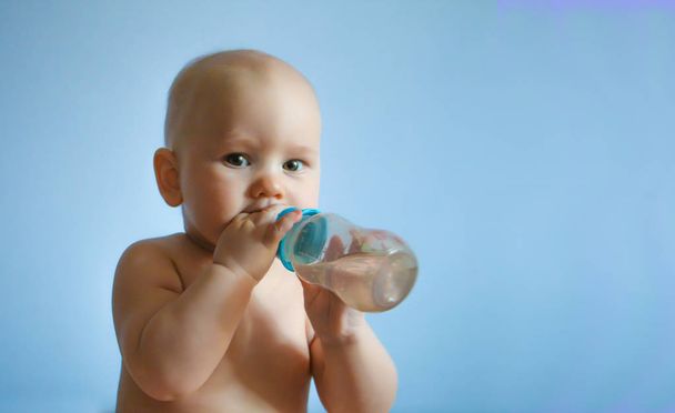 portrait of carefree happy baby holding a pacifier with milk in his hands - Foto, imagen