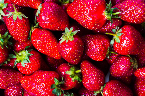 Ruwe aardbei fruit maken een rode achtergrondpatroon - Foto, afbeelding