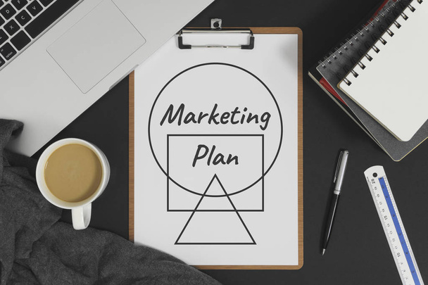 Plan de marketing escrito en papel blanco colocado con el ordenador portátil. Concepto de negocio y marketing
. - Foto, Imagen