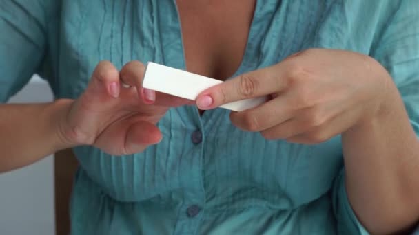 Home manicure and nail care concept. Woman using nail file for make shape to nails while home manicure. Woman doing yourself home manicure. - Materiał filmowy, wideo