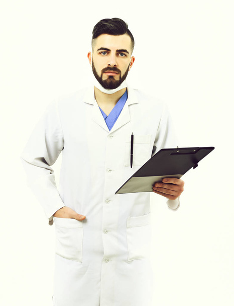 Man with concentrated face in white coat. Dentist in mask - Foto, afbeelding
