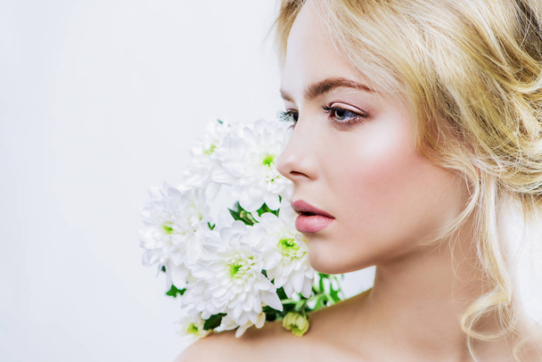 Close-up portrait of a beautiful romantic young woman with flowers. Copy space. Cosmetics, healthcare. Beauty, fashion concept. - Photo, image