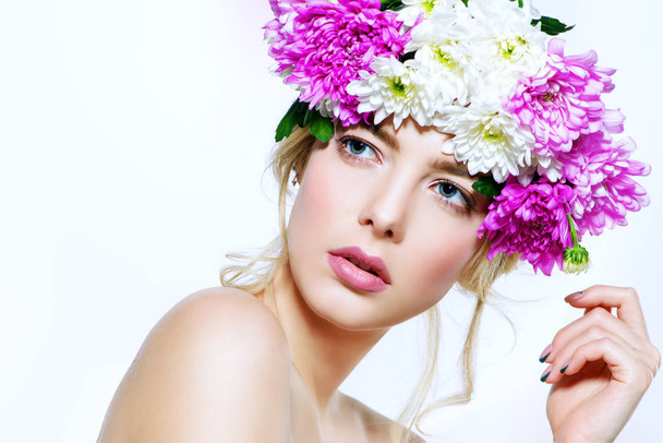 Portrait of a sensual spring lady in a wreath of flowers. Beauty, cosmetics. Make-up. White background. Copy space.  - Фото, изображение