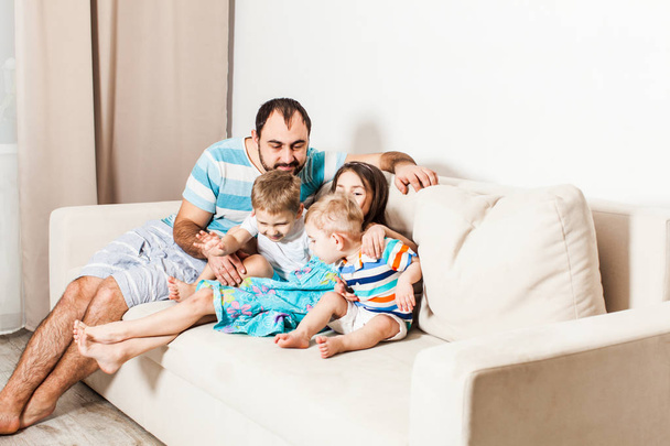 Man with his children sitting on the white sofa. - Fotografie, Obrázek