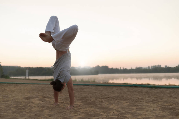 Athletic capoeira performer workout training on the beach sunris - Foto, Imagem