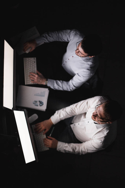 two businessmen making a financial report in the evening. - Photo, image