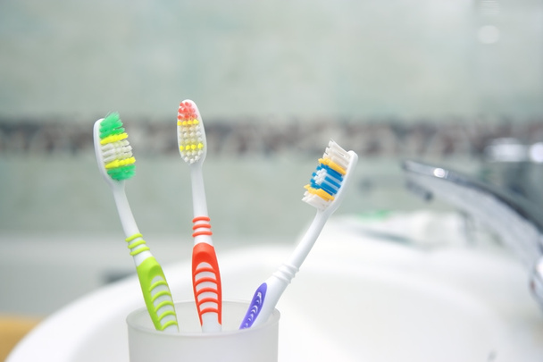 Tres cepillos de dientes en un baño. Primer plano de cepillo de dientes
. - Foto, Imagen