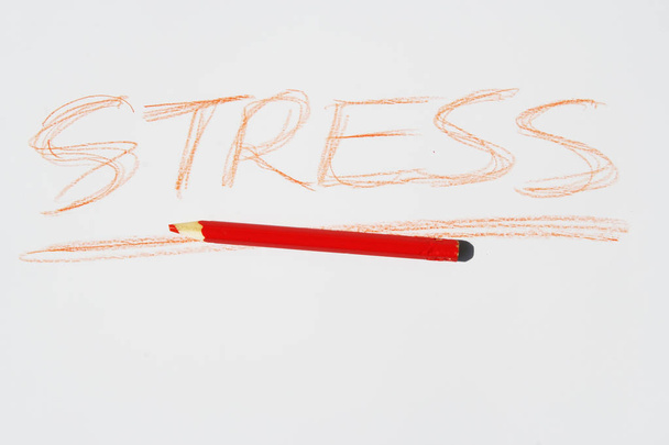 Red crayon and a stress note. Expressing stress syndrome with a note. - Photo, Image