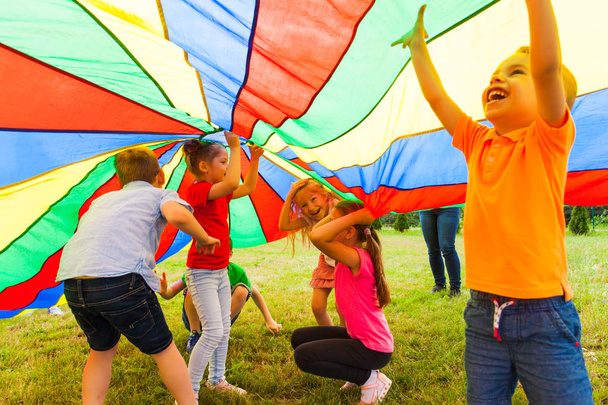 Close up view of children under the huge rainbow cover - Foto, Imagen