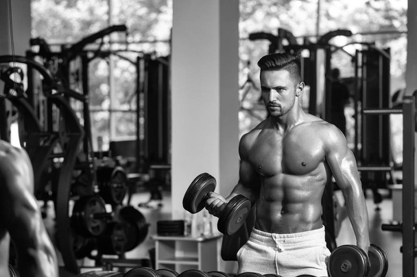 Training with dumbbells. muscular man with dumbbell - Photo, image