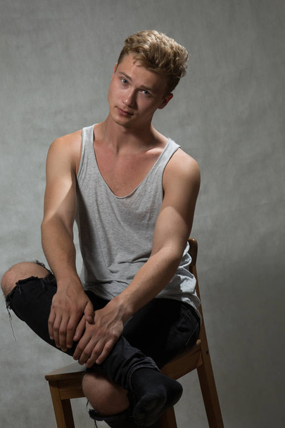 A shoot of young caucasian handsome blonde man against grey background. - Fotoğraf, Görsel