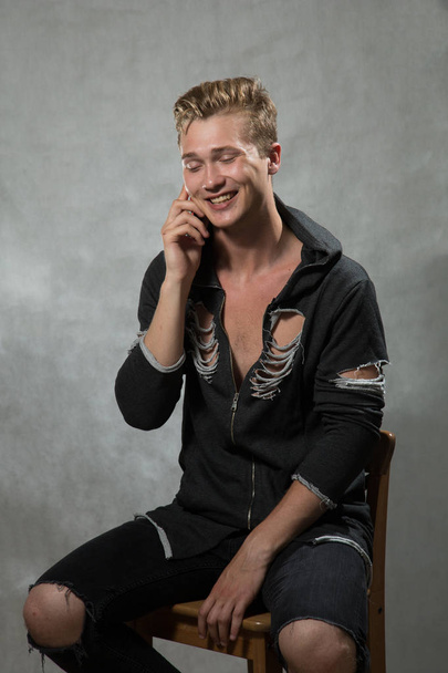 A shoot of young caucasian handsome blonde man against grey background. - Zdjęcie, obraz