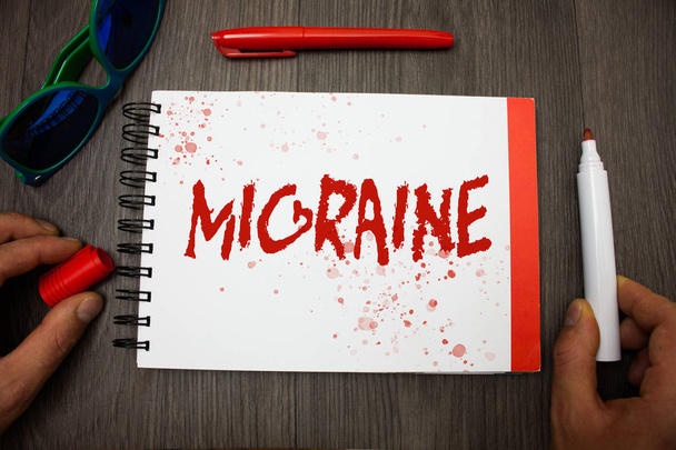 Handwriting text writing Migraine. Concept meaning Recurrent headache in one side of head nausea and disturbed vision Googles glasses pen marker cap notepad notebook highlighter eye sight - Foto, Imagem