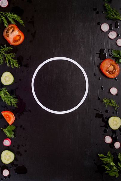 border with sliced fresh vegetables on black background. Proper nutrition concept. Round frame - Zdjęcie, obraz