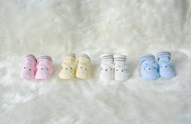 Collection of socks for newborn babies on the white fur background. - Фото, изображение