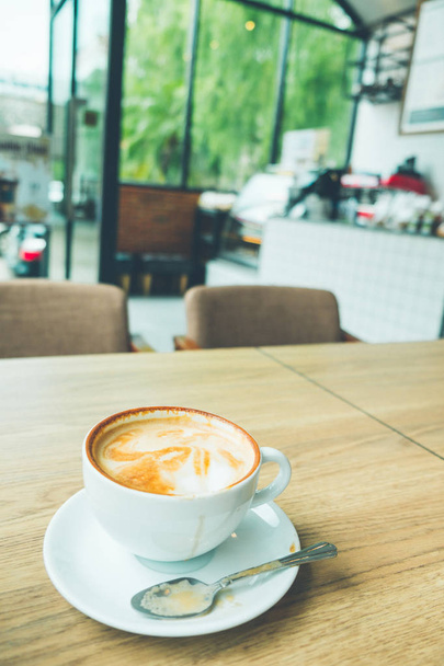 Kahvi latte taidetta pieni puu puinen työpöytä kahvilassa vintage väri sävy
 - Valokuva, kuva
