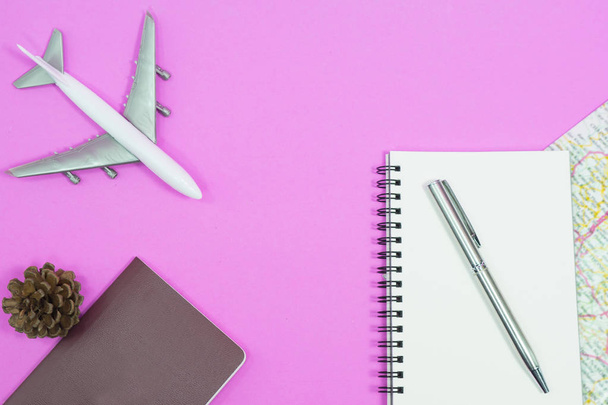 Travel concept. Blank notebook with pen and map on pink background. - Photo, Image