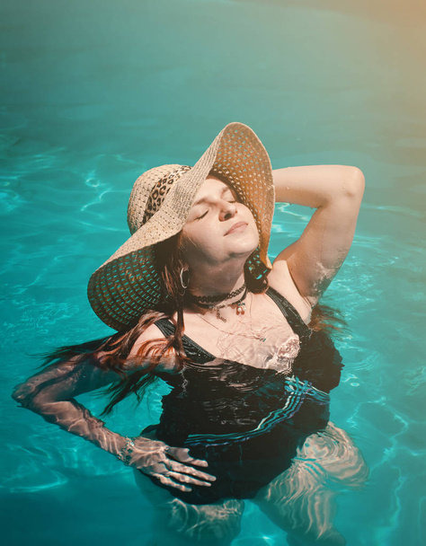 The young woman with hat in swimming pool - Fotoğraf, Görsel