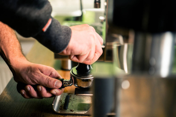 Homme barista préparation portafilter pour espresso shot. Moulin à café flou et machine
. - Photo, image