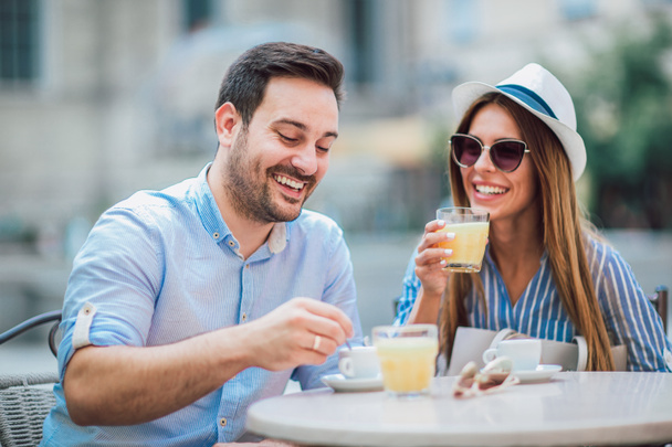 Пара сидящих в кафе, наслаждающихся кофе и беседой
 - Фото, изображение