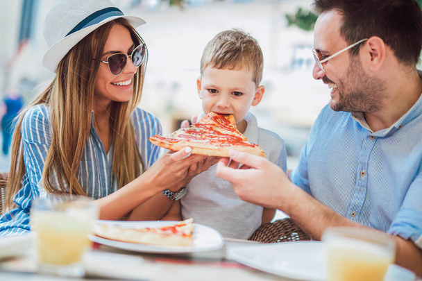 Porträt einer glücklichen Familie, die Zeit in einer Pizzeria verbringt - Foto, Bild