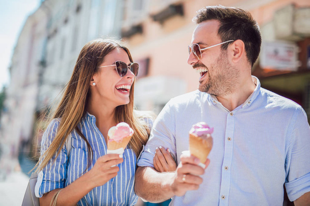 幸せなカップルの日付を持つと、ショッピングの後にアイスクリームを食べる - 写真・画像