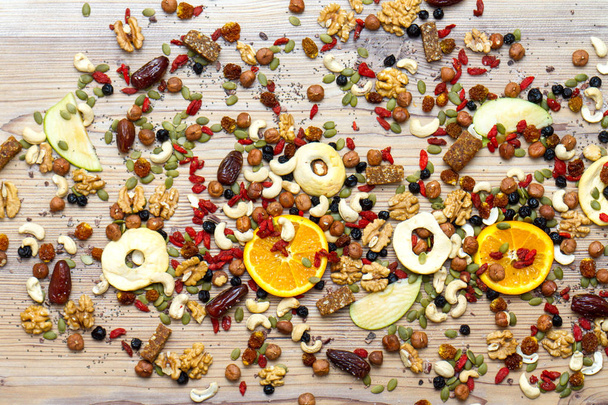 Mix of dried fruits, nuts and healthy raw snack bars background texture on table. - Zdjęcie, obraz