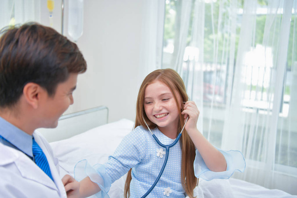 Gesundheitskonzepte. Der Arzt untersucht den Gesundheitszustand des Kindes. Kinder freuen sich im Krankenhaus. - Foto, Bild