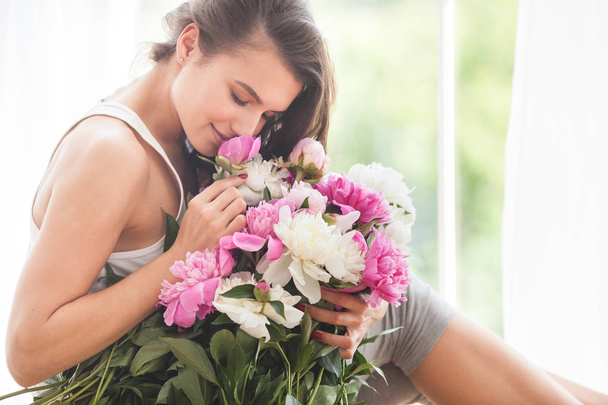 Młoda atrakcyjna kobieta z piwonii różowe i białe kwiaty - Zdjęcie, obraz