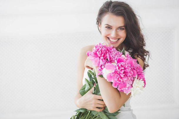 Young attractive woman with pink and white peony flowers - Foto, immagini