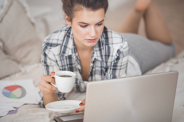 Young attractive woman working home at the laptop - Photo, image
