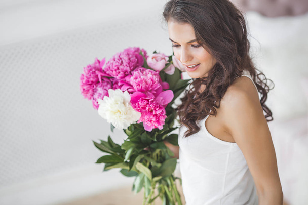 Nuori houkutteleva nainen vaaleanpunainen ja valkoinen pioni kukkia
 - Valokuva, kuva