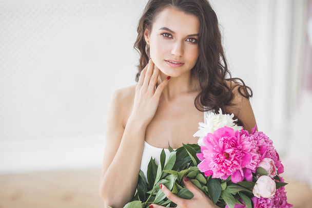 Young attractive woman with pink and white peony flowers - Foto, Bild