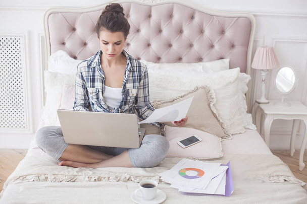 Jovem mulher atraente trabalhando em casa no laptop
 - Foto, Imagem