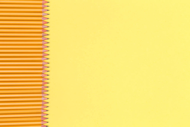 Fila de lápis em um fundo amarelo. De volta ao conceito de escola. Horizontal
 - Foto, Imagem