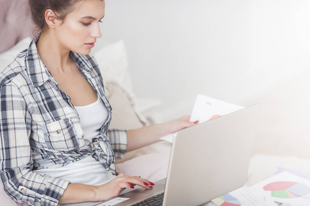 Young attractive woman working home at the laptop - 写真・画像