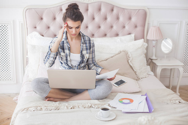 Jovem mulher atraente trabalhando em casa no laptop
 - Foto, Imagem