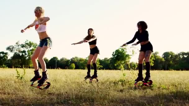 Três meninas em botas em molas realizar exercícios de queima de gordura no treinamento em grupo
 - Filmagem, Vídeo