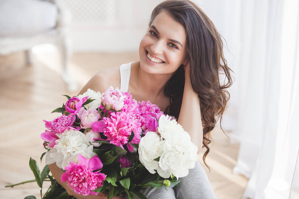 Jovem mulher atraente com flores de peônia rosa e branca
 - Foto, Imagem
