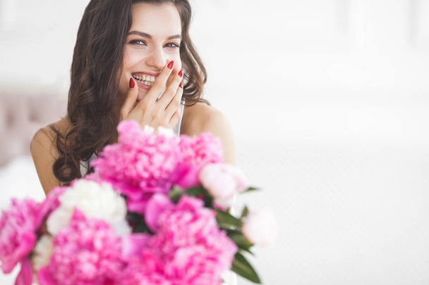 Mujer atractiva joven con flores de peonía rosa y blanca
 - Foto, imagen