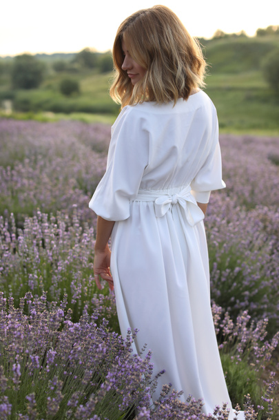 紫のラベンダー畑に白いドレス立って魅力的な女性の背面図  - 写真・画像
