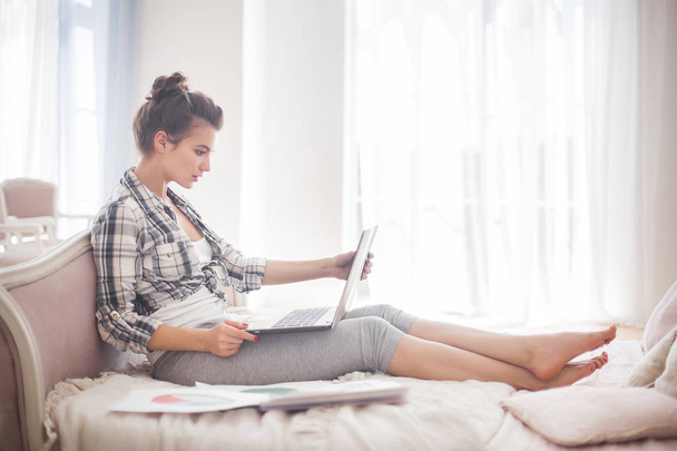 Fiatal, vonzó nő munka otthon a laptop. Lány, pihentető, és munkából pihenő - Fotó, kép
