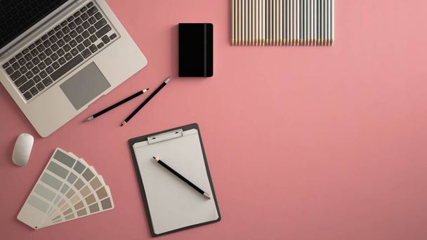 Mesa de escritório mínima elegante. Espaço de trabalho com laptop, notebook, lápis e paleta de cores de amostra em fundo rosa pastel. Deitado plano, vista superior
 - Foto, Imagem