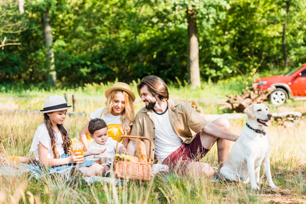 happy parents and children spending time at picnic with dog - Photo, Image