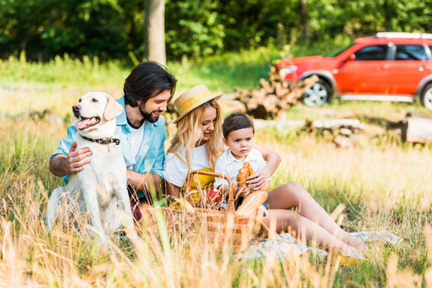 happy family spending time at picnic with dog - Photo, Image