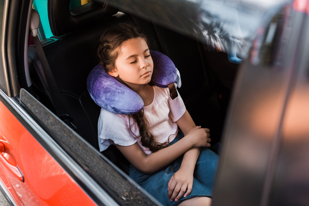 adorable niño durmiendo en coche con almohada para el cuello
 - Foto, Imagen