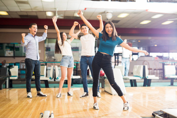 Happy multietnické přátelé těší vítězství stoje v bowling Clubu  - Fotografie, Obrázek