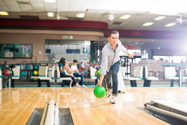 Celé délce vyhrazené dospívajícího chlapce hrát bowling s zelené koule v klubu - Fotografie, Obrázek